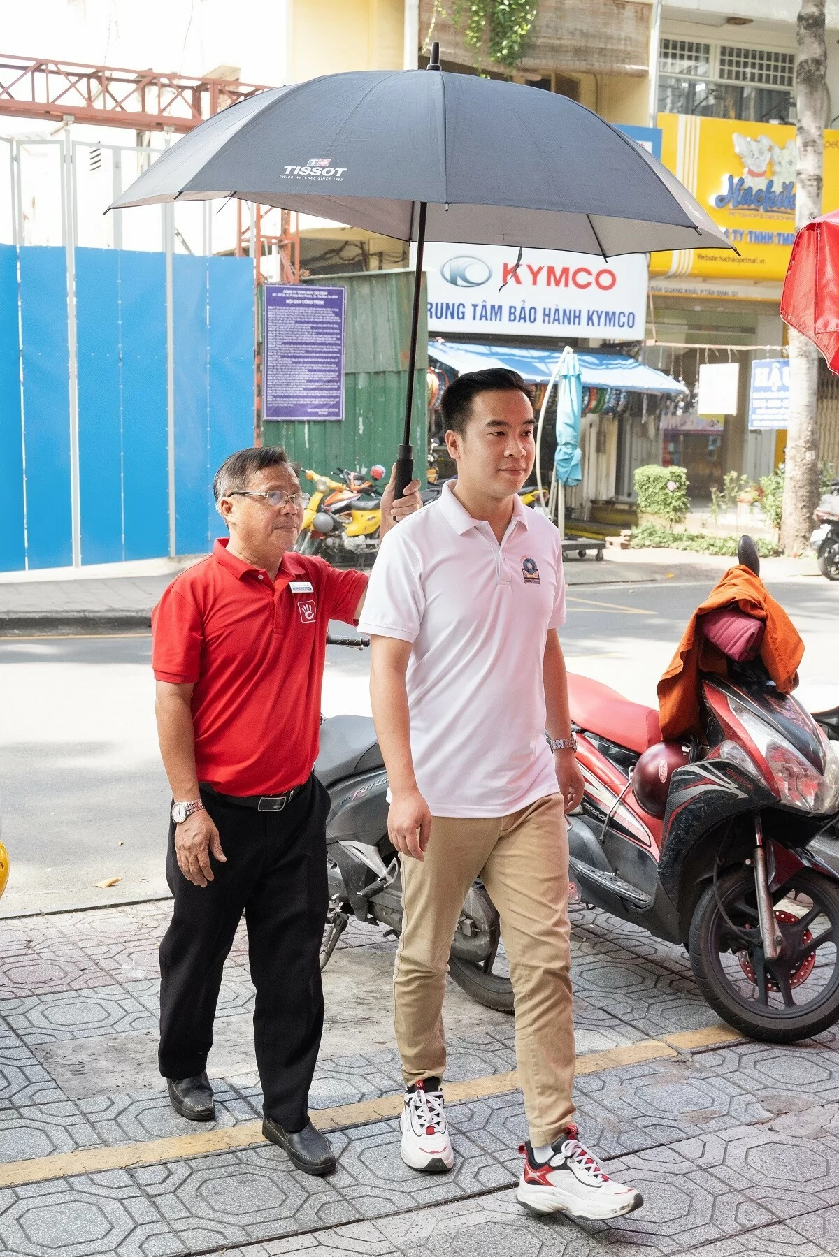 Hình ảnh chú Welcomer đang che ô khi trời nắng