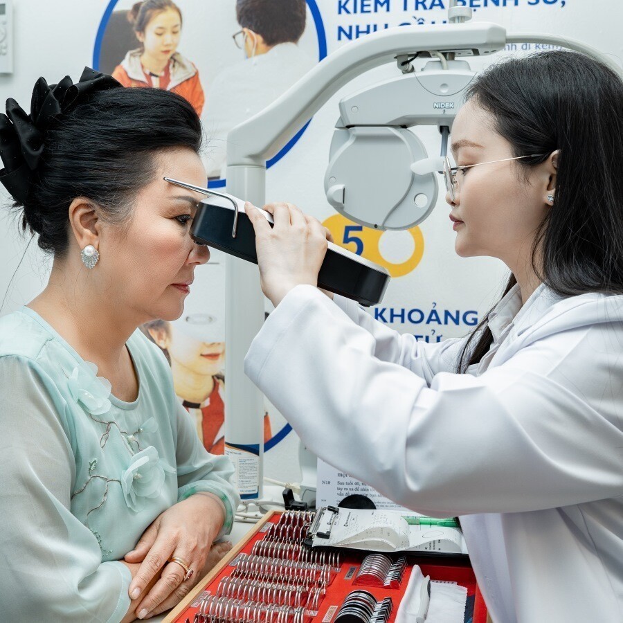 Kỹ thuật viên khúc xạ đang đo mắt cho khách hàng