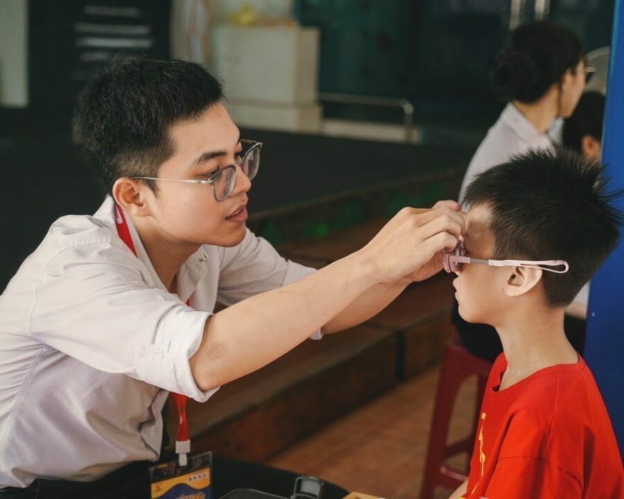 Kỹ thuật viên Hải Triều đang đo mắt cho bé trong dự án thiện nguyện
